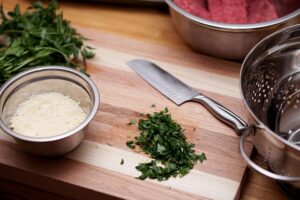 kitchen, cooking, knife, cilantro, mixing bowl, strainer bowl, strainer, kitchenware, parmesan, shredded cheese, shredded parmesan, cutting board, wood cutting board, kitchen, kitchen, kitchen, kitchen, cooking, cooking, cooking, cooking, cooking, knife, cutting board