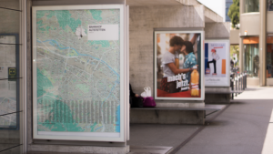 advertisement, billboard, outside, poster, train station, gray train, billboard, billboard, billboard, billboard, billboard, poster